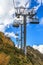 People ride on chair ski lift of Gorky Gorod mountain resort on autumn Caucasus mountains background. Sochi, Russia