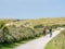 People riding bikes on bicycle path in dunes of nature reserve Het Oerd on West Frisian island Ameland, Friesland, Netherlands