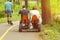 People riding pedal car, back view. New sports and recreation activities in the spring sunlit park.