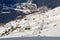 People rise using the ski lift on the background of the city Dombai winter sunny day