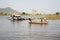 People rowing oars standing on boat