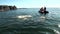 People in rubber boat near group of walruses in water of Arctic on New Earth.