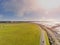 People running on a foot path. South park, Galway city, Ireland. Sunny day, Cloudy sky, Sun flare. Aerial view