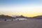 People rush on ATVs along the sandy road between the mountains i