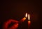 People`s hands are lit by candles in the dark. Design for the background, hand with candle