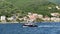 People sail in a motorboat against the backdrop of luxury villas