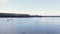 People are sailing on a boat on a gray river that spilled in the spring. Dark forest in the background. Cloudy day, pond