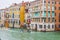 People sailing boats and water taxis beside gothic Venetian buildings on a rainy November day on the Grand Canal waterway, Venice.