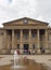 people in saint georges square huddersfield in front of the facade of the historic victorian train station