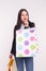 People, sale and consumerism concept - Attractive woman dressed in black jacket over white background holding shopping