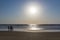 People in a sea on a sunset, Arambol beach, Goa, India. Paragliding on the background