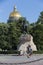 People on Senate Square by the Bronze Horseman equestrian statue of Peter the Great. St. Isaac`s Cathedral golden cupola dome