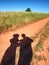 People shadows on old dusty road with ferric red soil.  Shadows