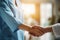 People shaking hands closeup, handshake between doctor and patient, blur room interior background