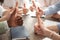 People showing thumbs up at table, closeup