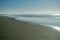 People silhouetted on the beach fishing and playing as the surf come in