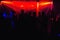 People silhouettes on dance floor of night club at the concert under red spotlights