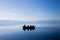 People silhouettes on a metal row boat in amazing blue water of Ohrid lake.