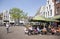 People sit and drink at outdoor cafe in city center of medieval utrecht in holland