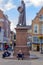 People sit in front of the statue of Hugo Grotius on the main market square in Delft, Netherlands