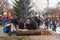 People sit on a log and bask around the fire in a city park