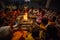 People sit near a ceremonial fire near the Holy Ganges at night.