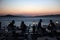 People sit in seaside restaurant at dusk