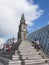 People sit on steps near central square in front of martini tower in groningen