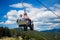 People sitting on chairlift summer hike in mountains
