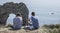 People sitting at the edge of a cliffs, Durdle Door.