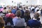 People Sitting In Lines During a Conference While Female Host Speaking on Stage.