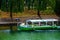 People sitting and looking to the river Ljubljanica while boat is passing in front of them in Ljubljana the capital city of