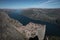 People sitting on Preikestolen rock with view into Lysefjord in Norway