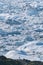 People sitting standing in front of huge glacier wall of ice. Icefjord Ilulissat. Jakobshaven Eqip Sermia Glacier Eqi