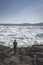 People sitting standing in front of huge glacier wall of ice. Icefjord Ilulissat. Jakobshaven Eqip Sermia Glacier Eqi