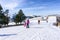 People skiing and snowboarding on a slope at ski resort