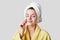 People, skin care and hygiene concept. Pleased female applies something on face with cotton wheel, has soft skin after taking bath