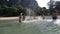 People Splashing In Water, Cheerful Young Man And Woman Group Having Fun On Beach In Mountains