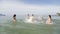 People Splashing Water On Man, Cheerful Young Friends Group Having Fun On Beach