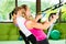 People in sport gym on suspension trainer