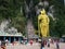 People in the square and climbing the stairs of the Batu Caves with the golden statue of Murugan. Malaysia