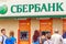 People stand in line at Sberbank ATM for various financial transactions