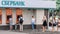 People stand in line at Sberbank ATM for various financial transactions