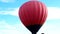 People stand near the inflated balloon before flying in the sky