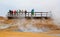 People standing near a steaming fumarole in geothermal area of Hverir, Iceland