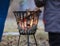 People standing by outdoor fireplace with glowing fire