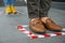 People standing on taped floor markings for social distance. Coronavirus pandemic