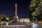People and statue at the Rossio Square in Lisbon at night