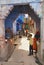 People at the street with historical traditionally blue painted old residential area buildings in downtown Jodhpur, India.