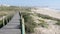 People stroll on the wooden boardwalk near Espinho beach, Portugal